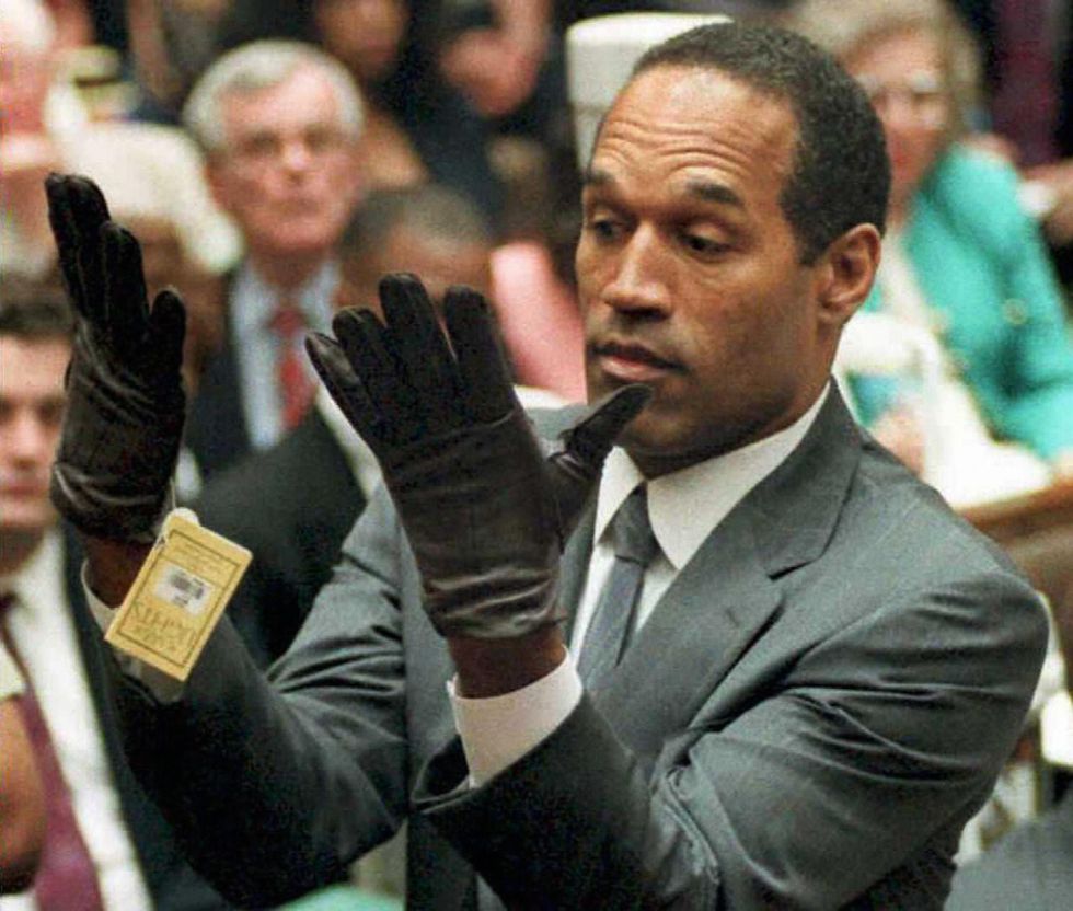 1995: Former US football player and actor O.J. Simpson looking at a new pair of Aris extra-large gloves that prosecutors had him put on during his double-murder trial in Los Angeles.
