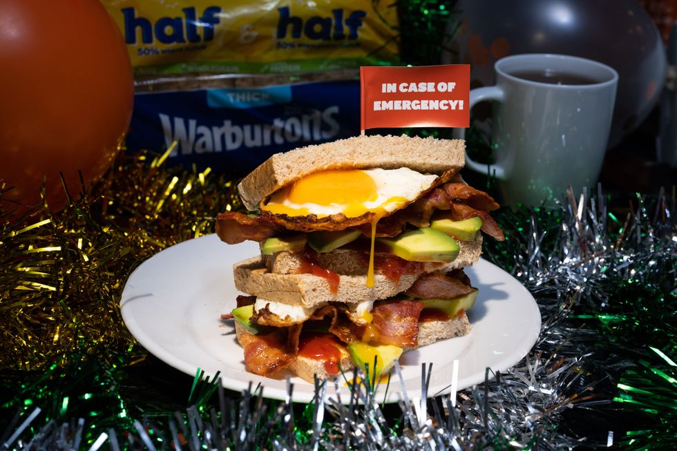 A bacon, egg, and avocado sandwich sits among tinsel