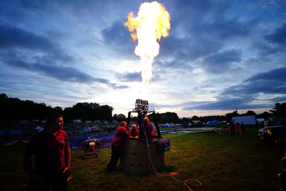 A balloonist tests his burner ahead of Friday morning's mass ascent (Ben Birchall/PA)