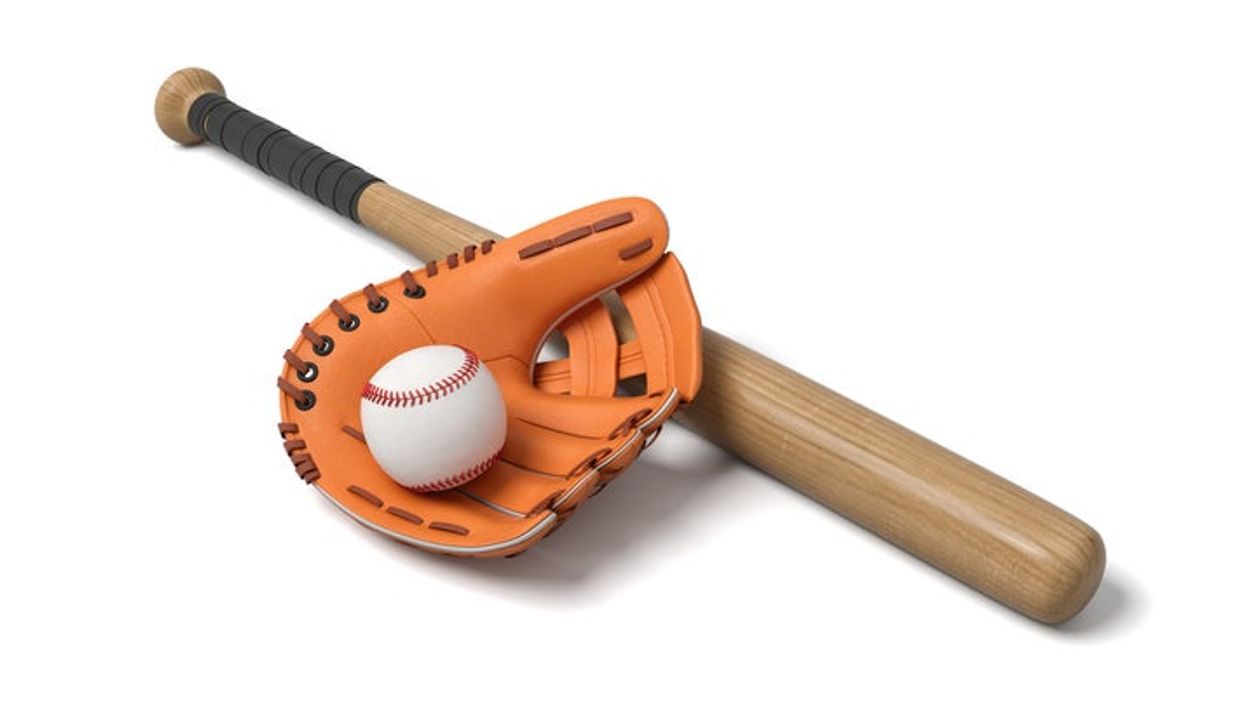 A baseball lies inside a large leather glove near a wooden bat on a white background.