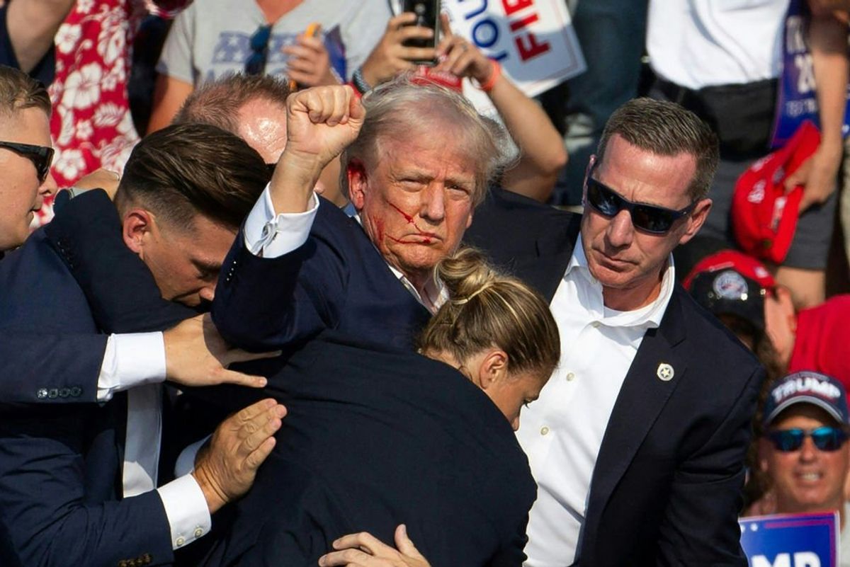 A bloodied Donald Trump stands defiant following the attempt on his life