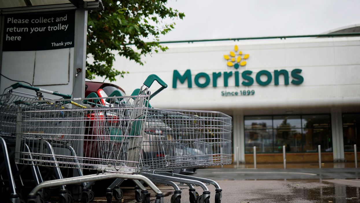 A bundle of shopping trolleys outside a Morrisons supermarket, with the front of the store in the background.