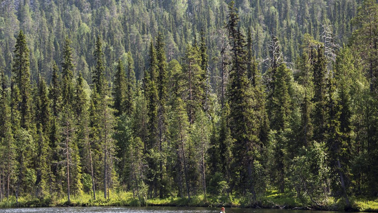 <p>A canoeist paddles on the Kesanki Lake in Akaslompolo, Kolari in Lapland, Northern Finland, on July 7, 2021 as the area continues to experience a record-breaking heatwave with temperatures topping 33 degrees Celsius</p>