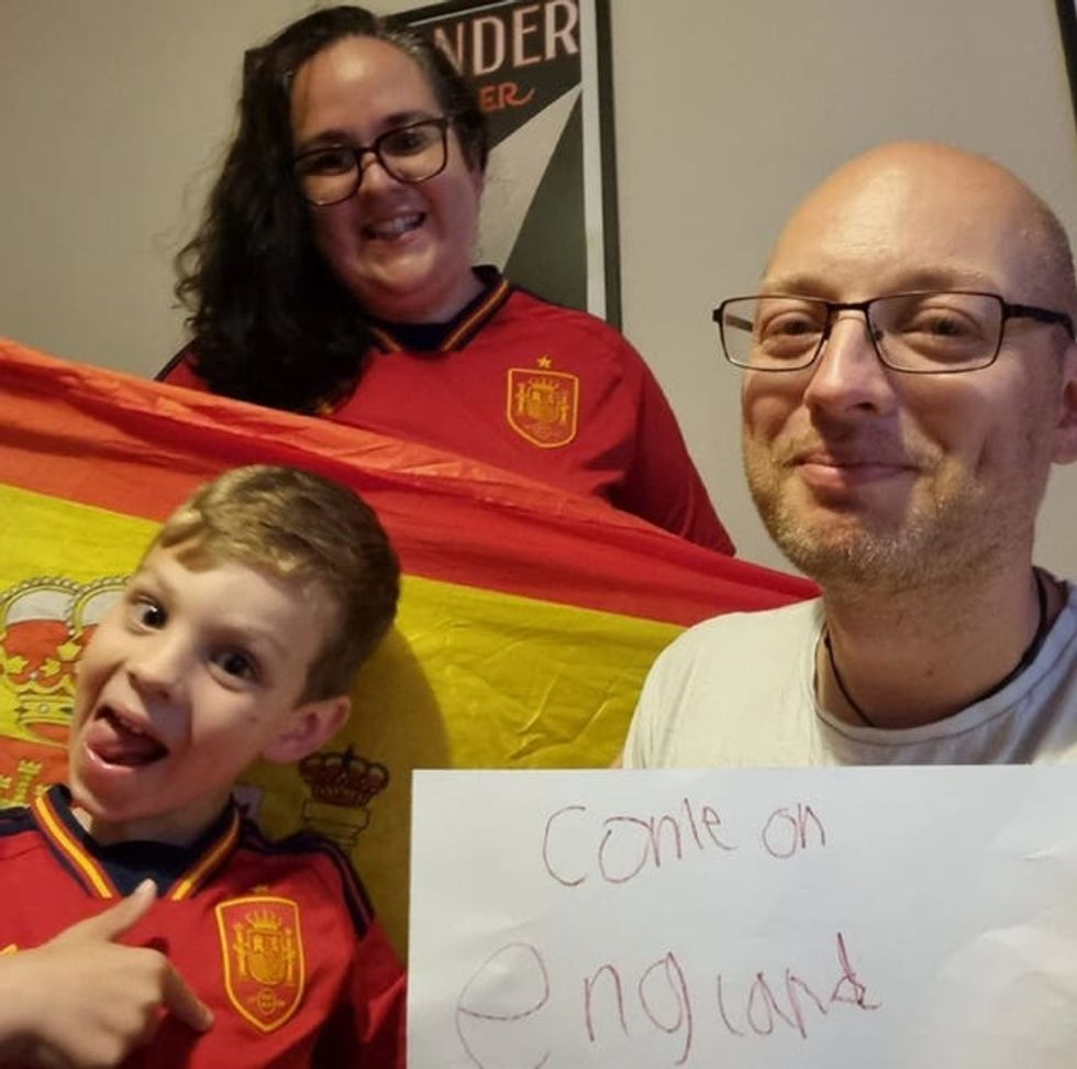 A child a woman and a man with a Spanish flag