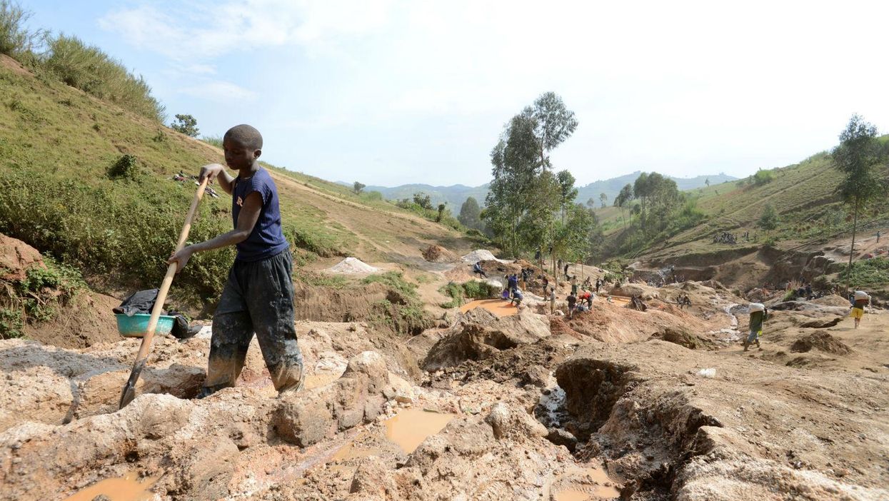A child separates mineral from rock and sand at a mine in DR Congo