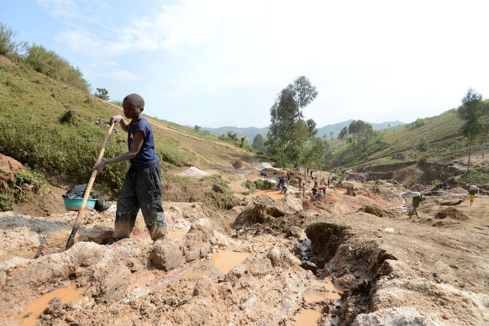 A child separates mineral from rock and sand at a mine in DR Congo