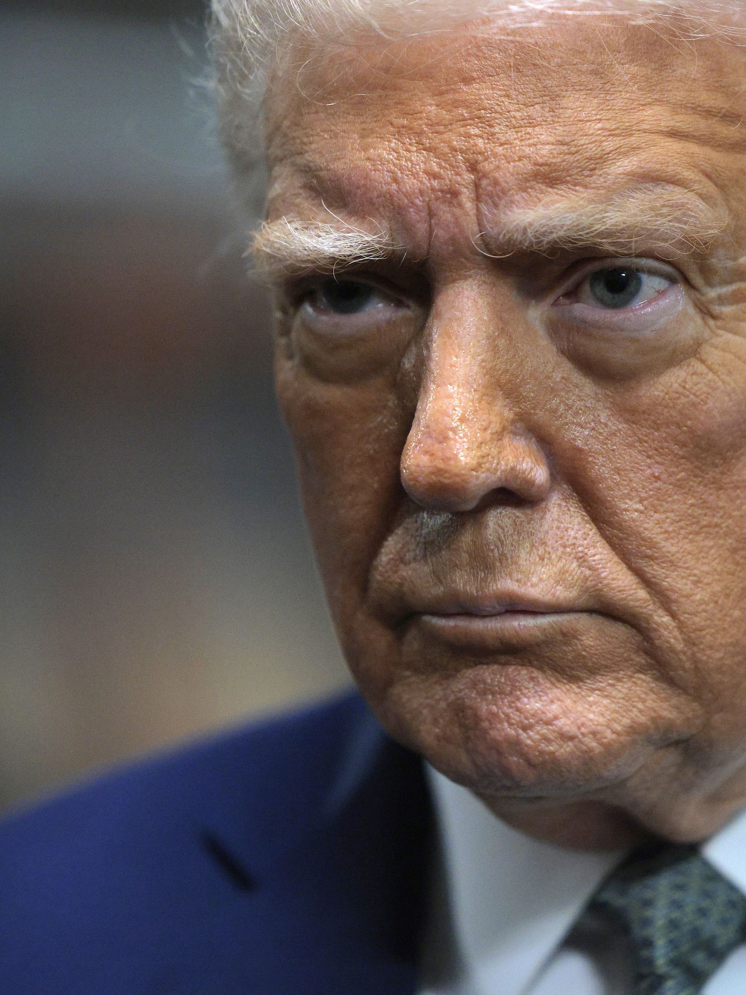 A close-up picture of Donald Trump, with a neutral expression on his face.