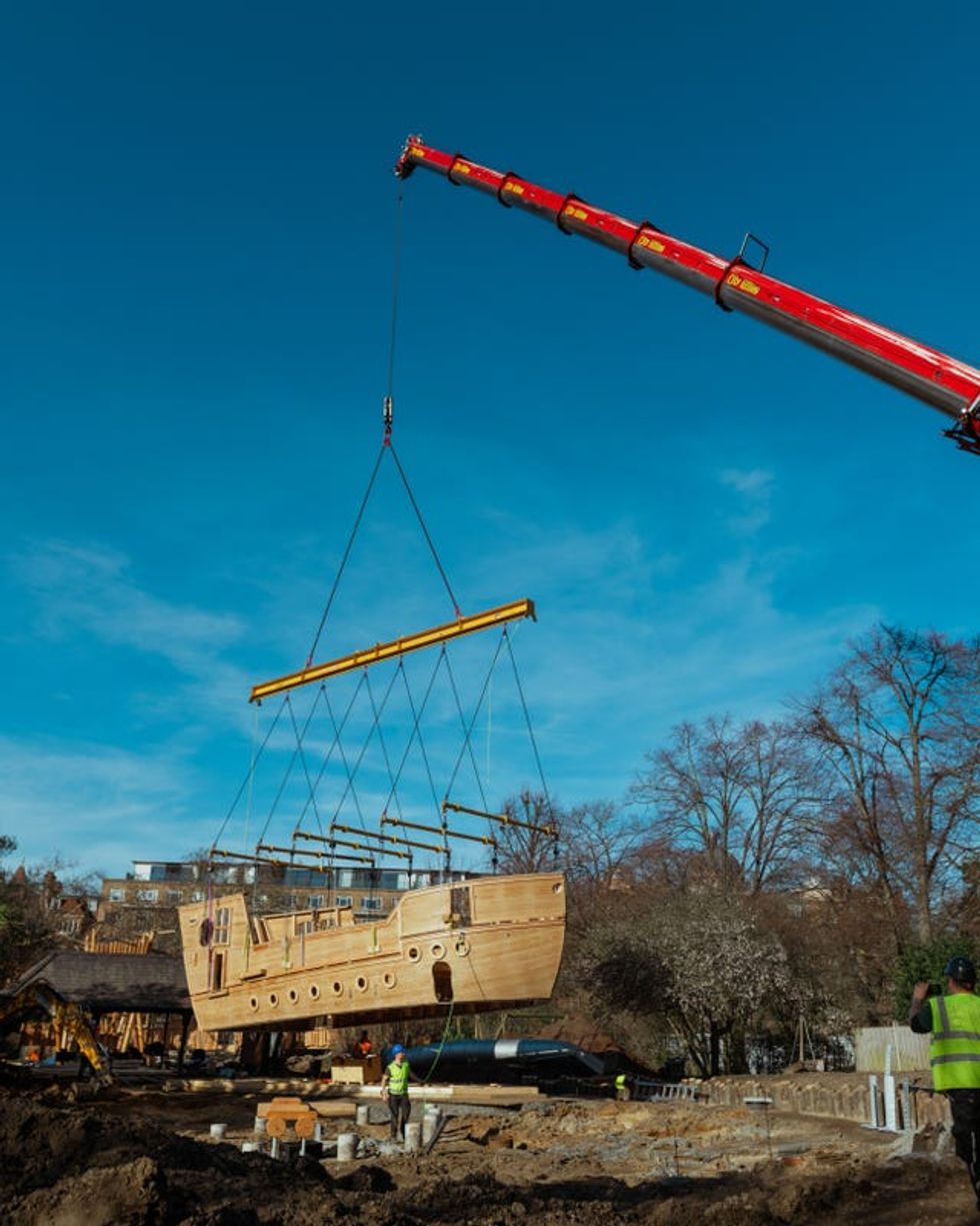 A crane lifts the wooden ship into the royal park