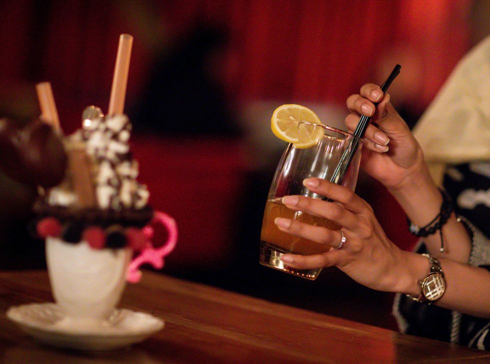 <p>A customer drinks a non-alcoholic drink in a cafe in Riyadh</p>