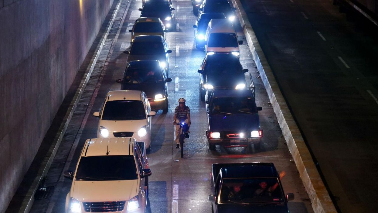 A cyclist is seen riding along one of the main streets of San Salvador on October 7, 2015