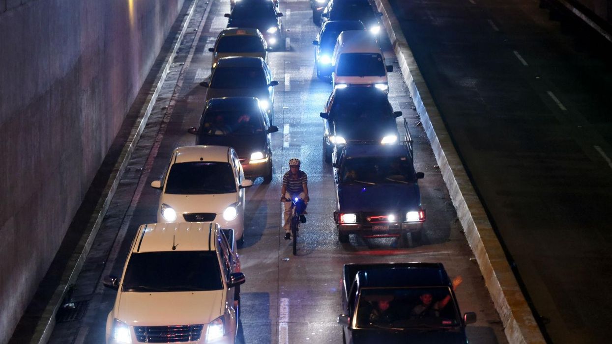 A cyclist is seen riding along one of the main streets of San Salvador on October 7, 2015