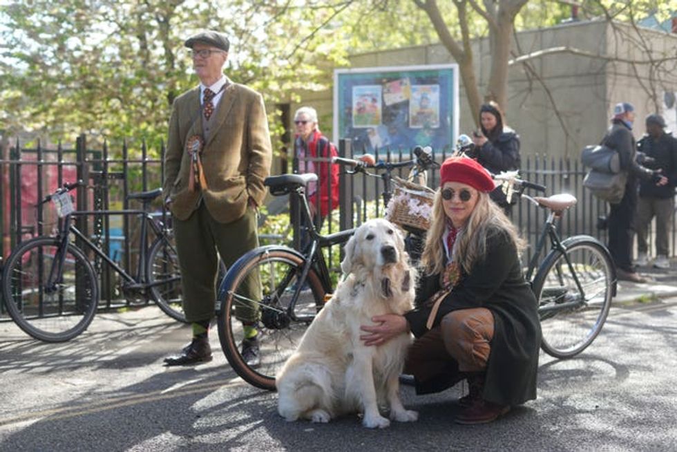 A cyclist poses for a photo with her dog