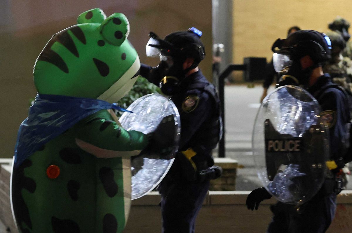 A demonstrator dressed in an inflatable frog costume confronts law enforcement officers during a protest outside of the ICE (Immigration and Customs Enforcement) headquarters in south Portland, Oregon, U.S.