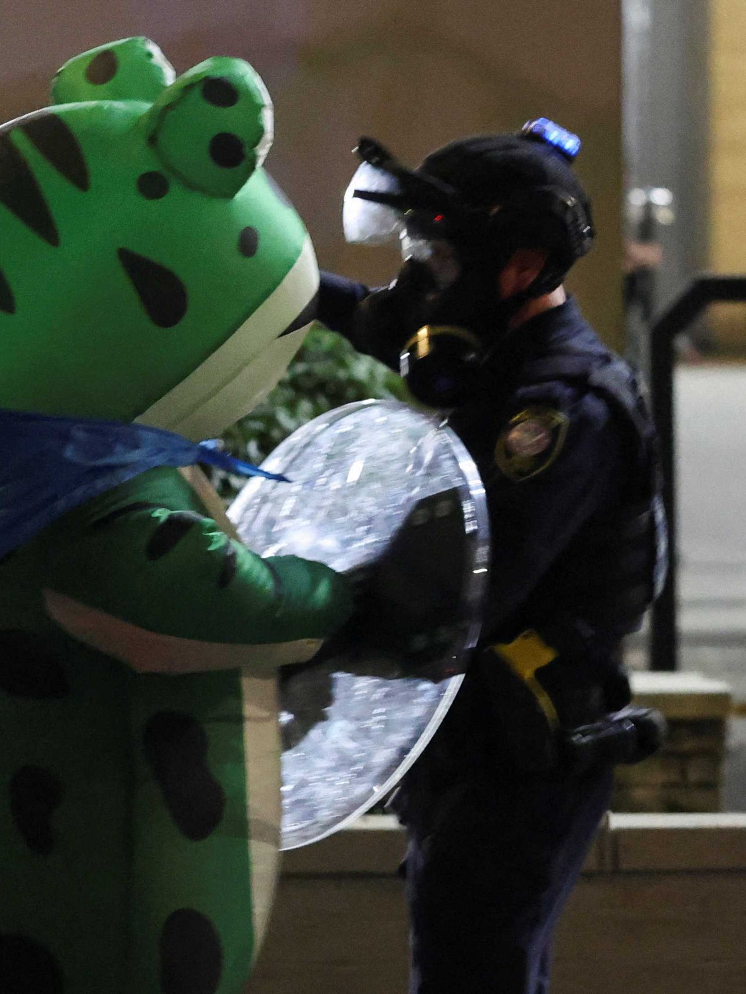 A demonstrator dressed in an inflatable frog costume confronts law enforcement officers during a protest outside of the ICE (Immigration and Customs Enforcement) headquarters in south Portland, Oregon, U.S.
