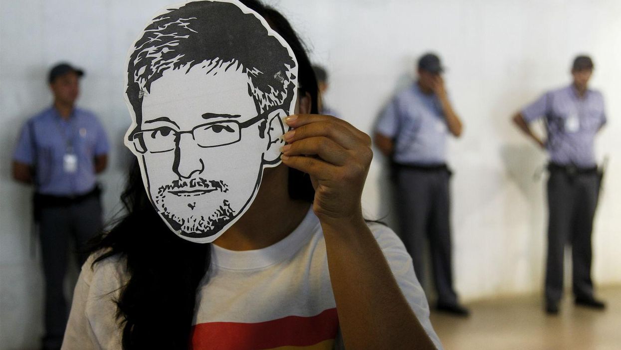 A demonstrator in Brasilia in February 2014 holds up an Edward Snowden mask during the delivery of a petition to grant the NSA whistleblower political asylum in Brazil.