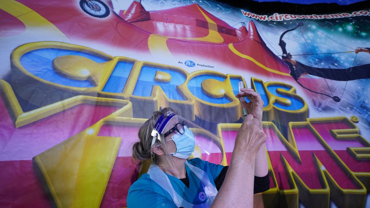 A doctor prepares a syringe at a pop-up Covid-19 vaccination clinic in the marquee of Circus Extreme in Halifax (Owen Humphreys/PA)