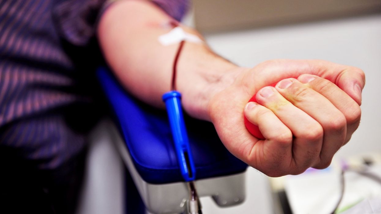 A donor squeezes a rubber ball while giving blood