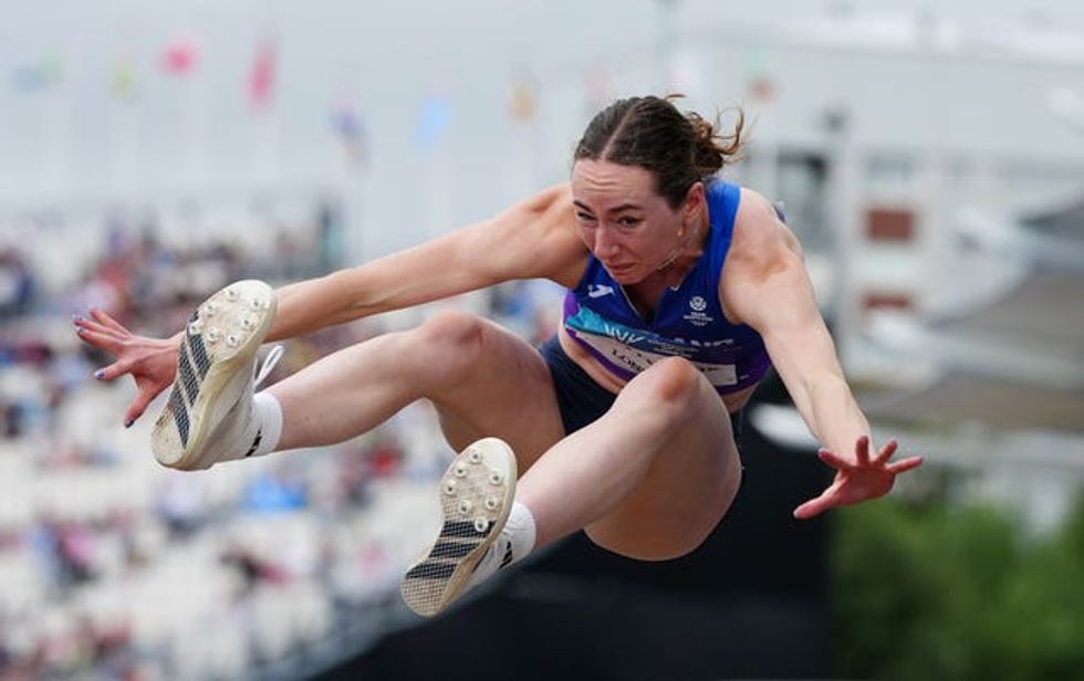 A female athlete takes part in the long jump