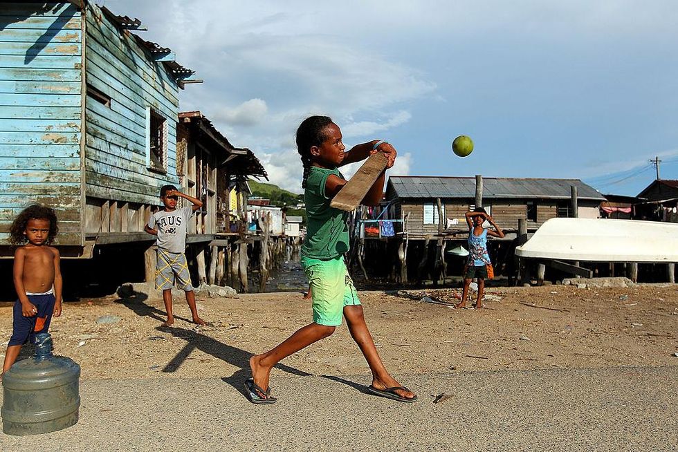 A girl from the village of Hanuabada bats during a game of cricket in the streets on February 24, 2012 in Port Moresby, Papua New Guinea. Picture: