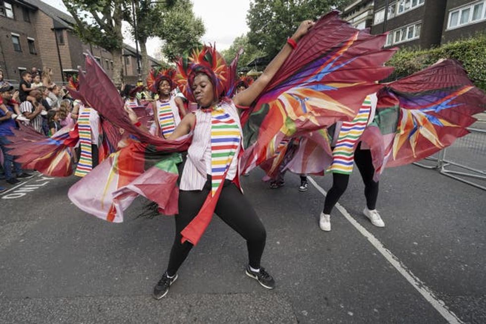 A group of dancers wave stripey wings as they move