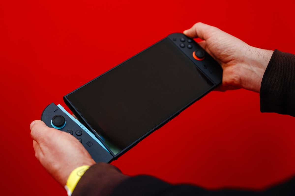 A guest holds of the new Nintendo Switch 2 video-game console system of Japanese video-game company Nintendo with the detachable Joy-con controllers during the worldwide presentation at the Grand Palais in Paris on April 2, 2025
