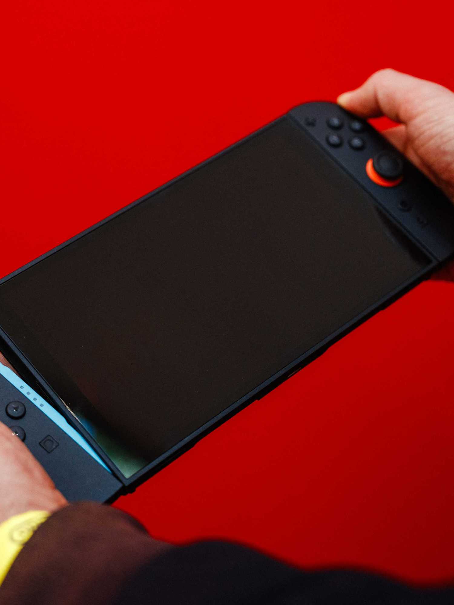A guest holds of the new Nintendo Switch 2 video-game console system of Japanese video-game company Nintendo with the detachable Joy-con controllers during the worldwide presentation at the Grand Palais in Paris on April 2, 2025