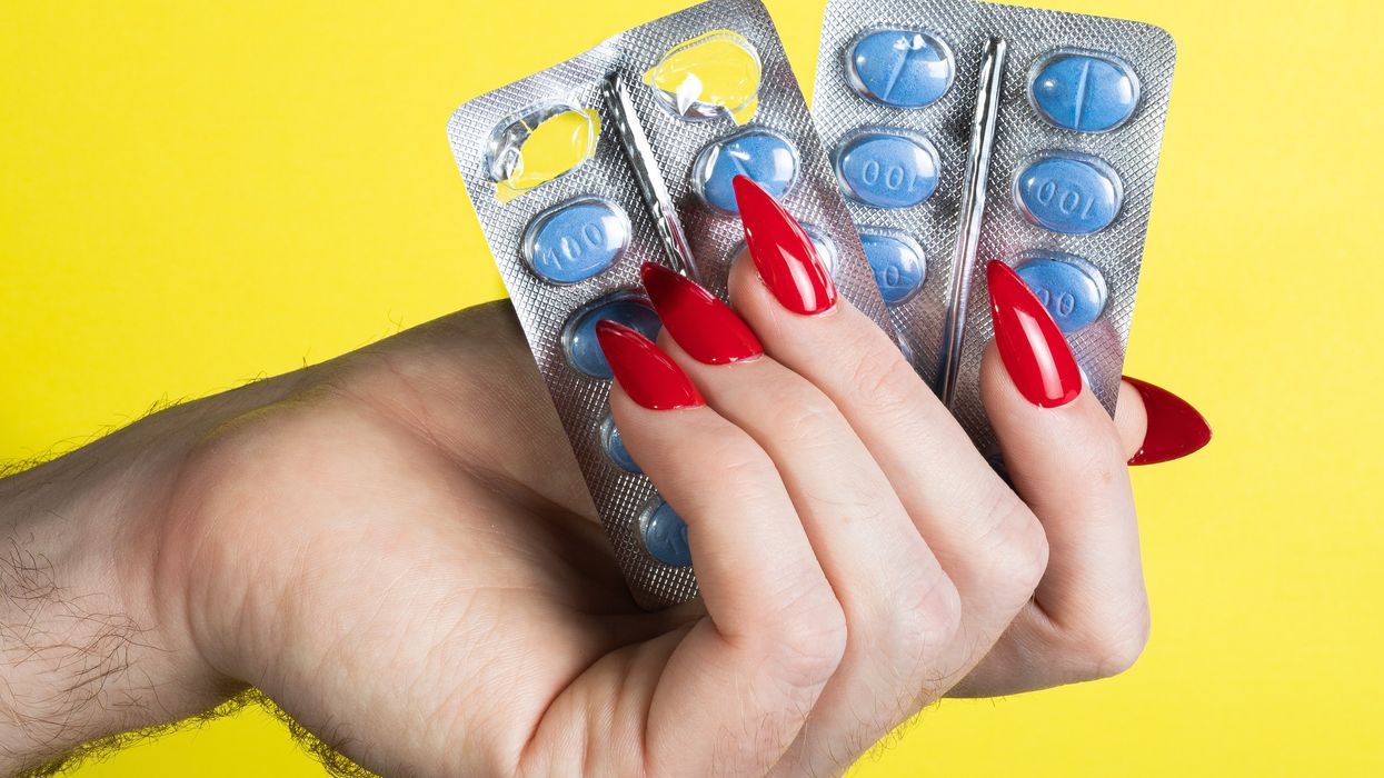 a hand holding two contraptions in front of a yellow background