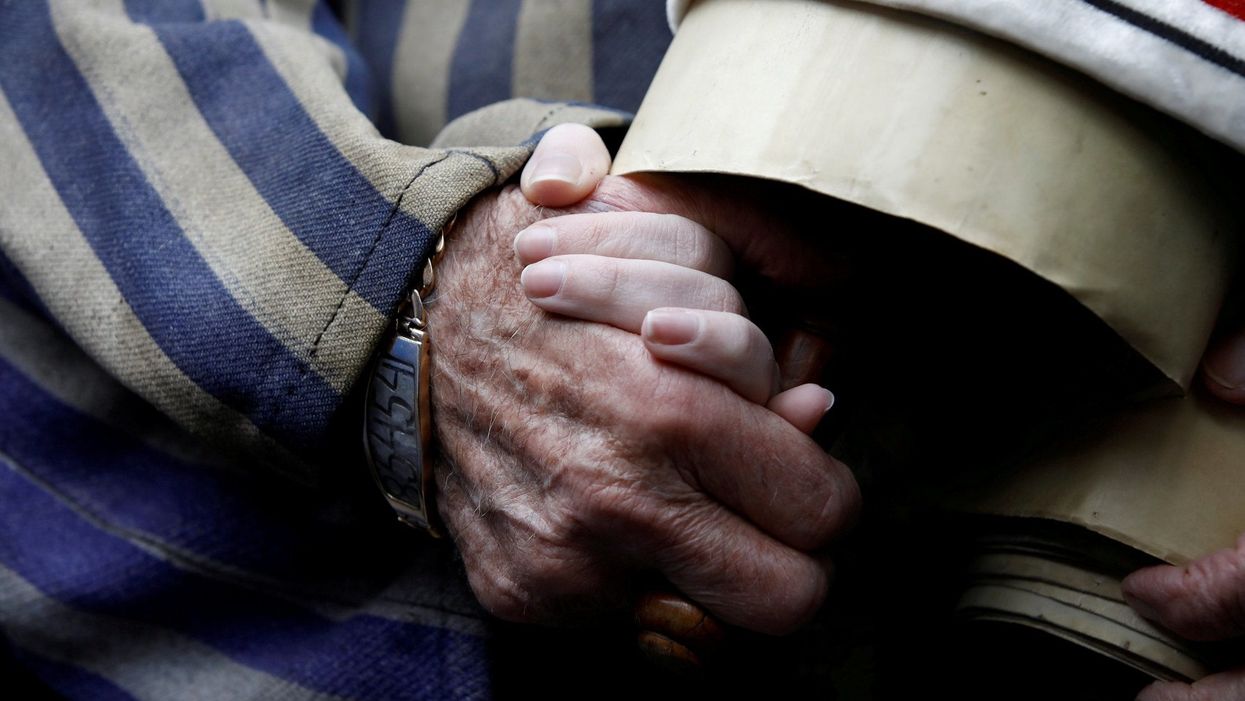 A Holocaust survivor holds his granddaughter’s hand as he arrives to take part in this year’s march in Poland
