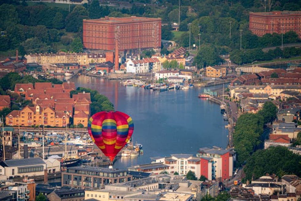 A hot air balloon takes to the sky over Bristol Harbour (Ben Birchall/PA)