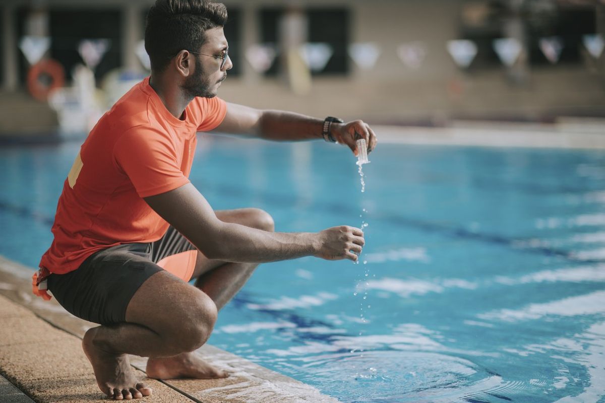 A lifeguard checks chlorine levels in a pool