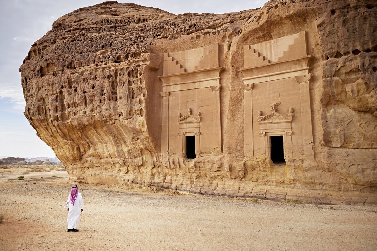 A man admires the Jabal Al-Ahmar tombs at Hegra