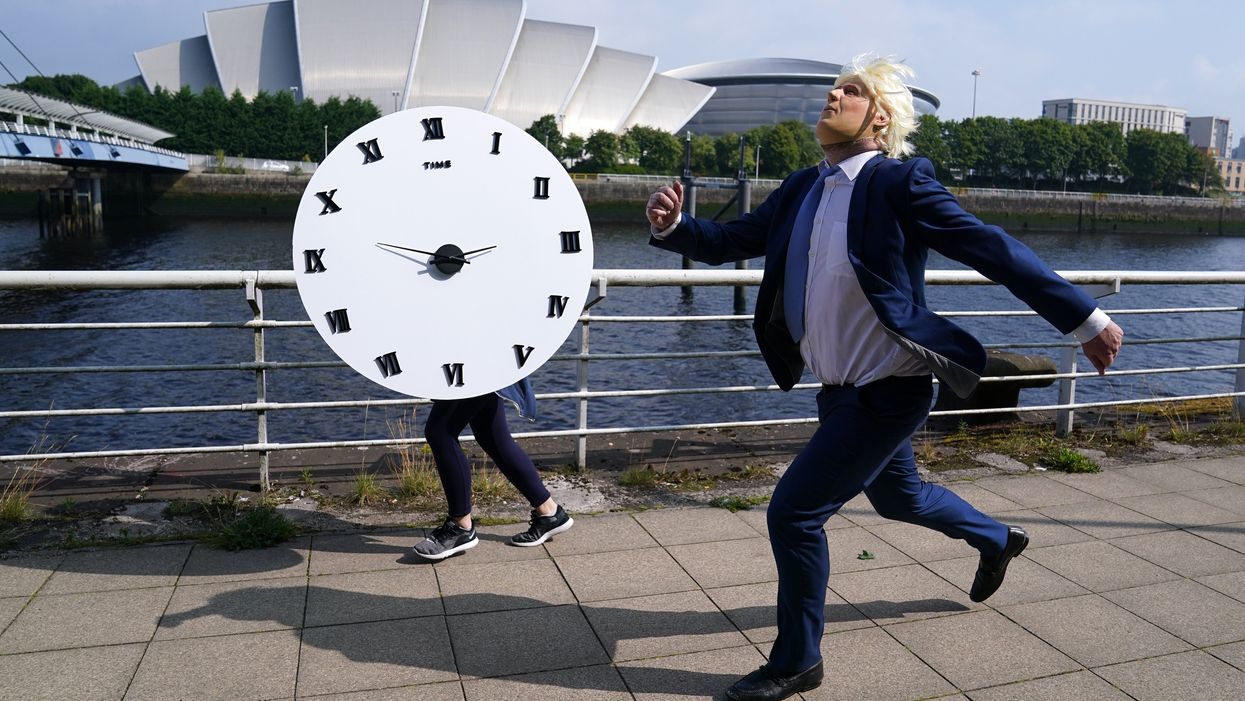 A man dressed as Prime Minister Boris Johnson races against a clock in Glasgow in the charity stunt (Andrew Milligan/PA)