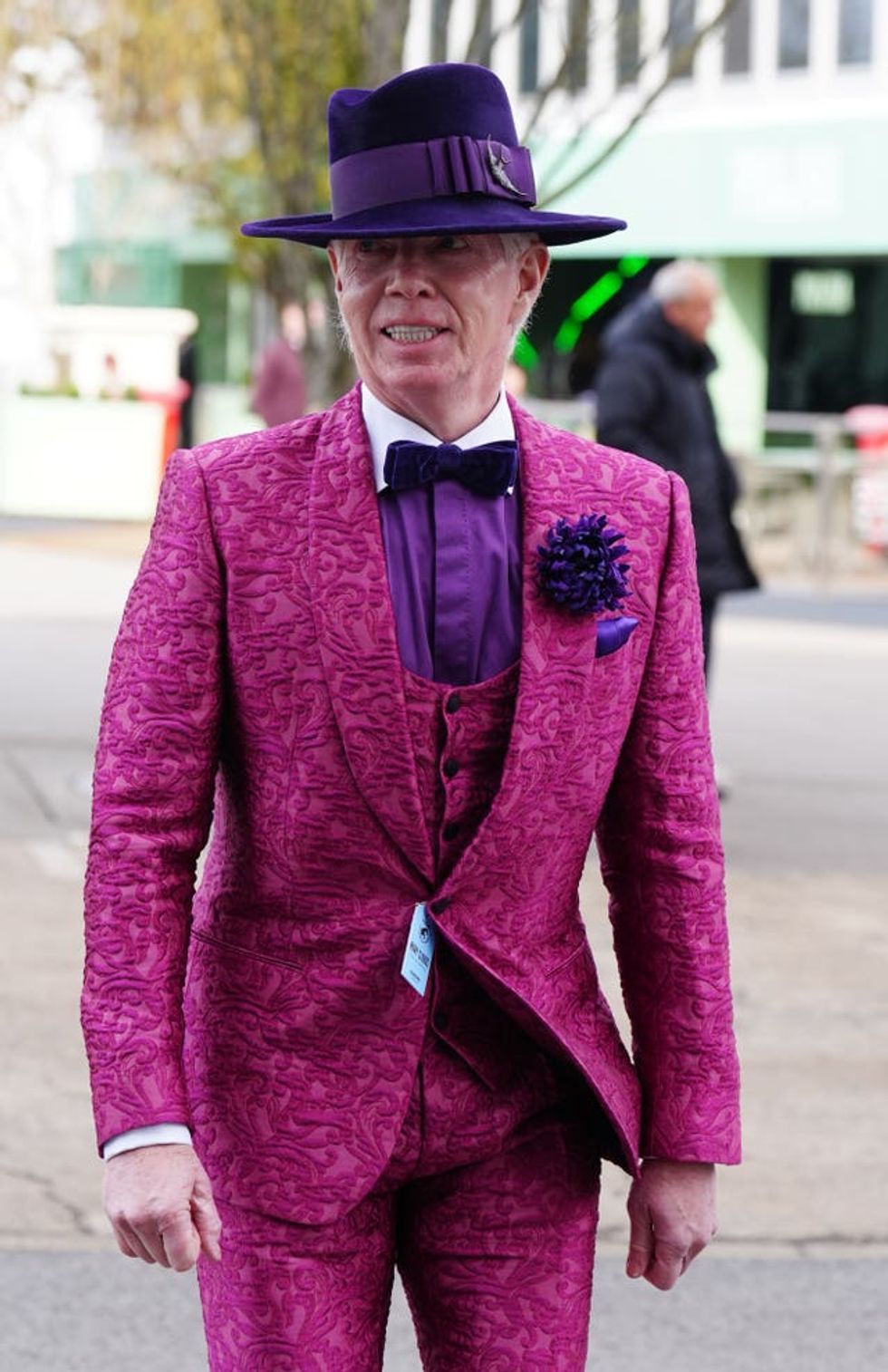 A man in a pink velour three-piece suit and purple fedora