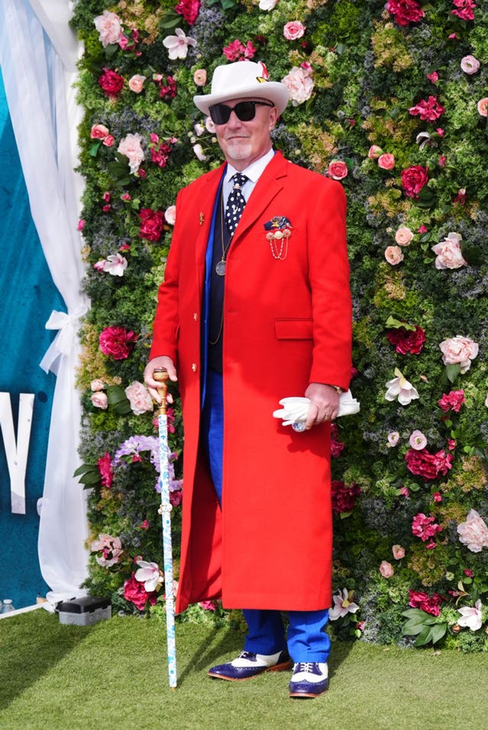 A man in a white hat and long red coat