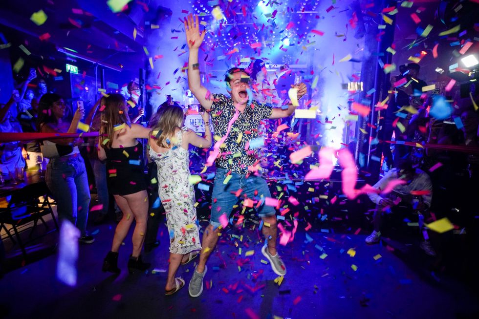 A man jumps on the dance floor shortly after the reopening, at The Piano Works in Farringdon, in London
