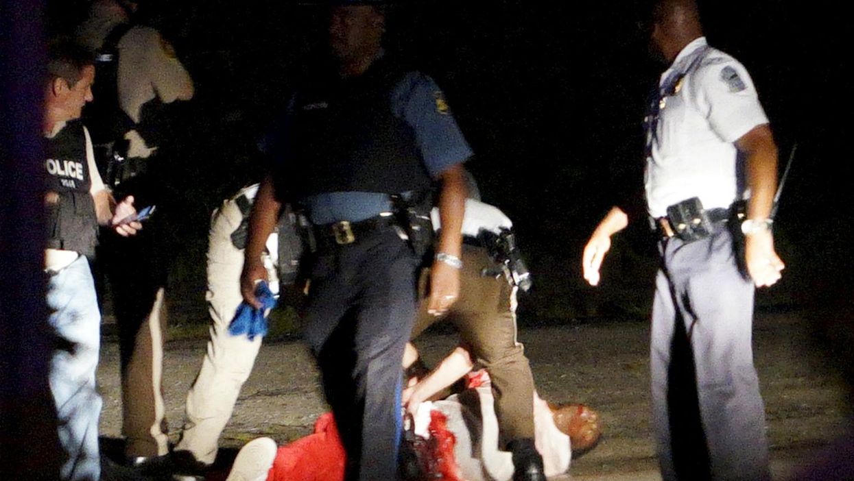 A man lies on the ground with blood on his shirt after a police officer involved shooting in Ferguson, Missouri on August 9th 2015.