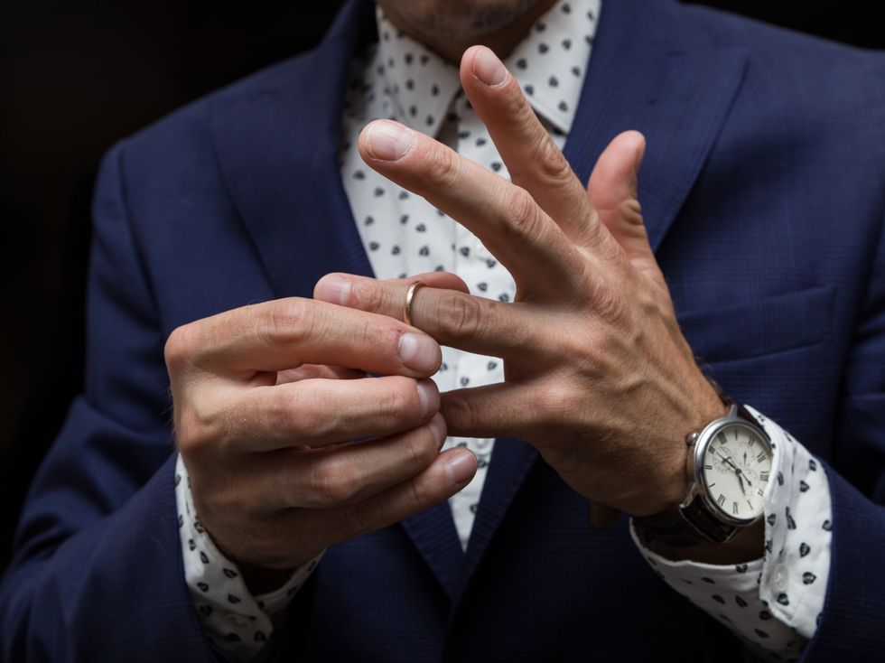 A man removing a wedding ring