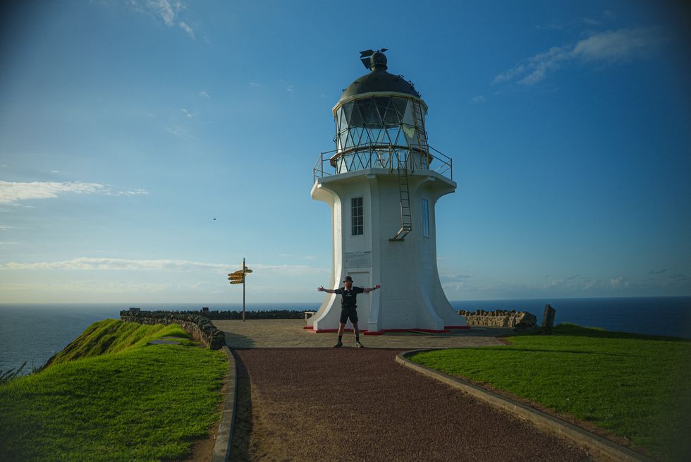 A man standing in front of a lighthouse