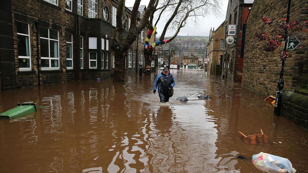 A man wades through floodwaters in Hebden Bridge, Yorkshire