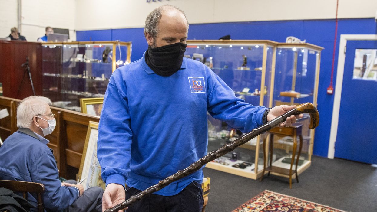 A member of the Bloomfield Auctions team holds a walking stick once owned by Northern Ireland’s first prime minister, James Craig (Liam McBurney/PA)