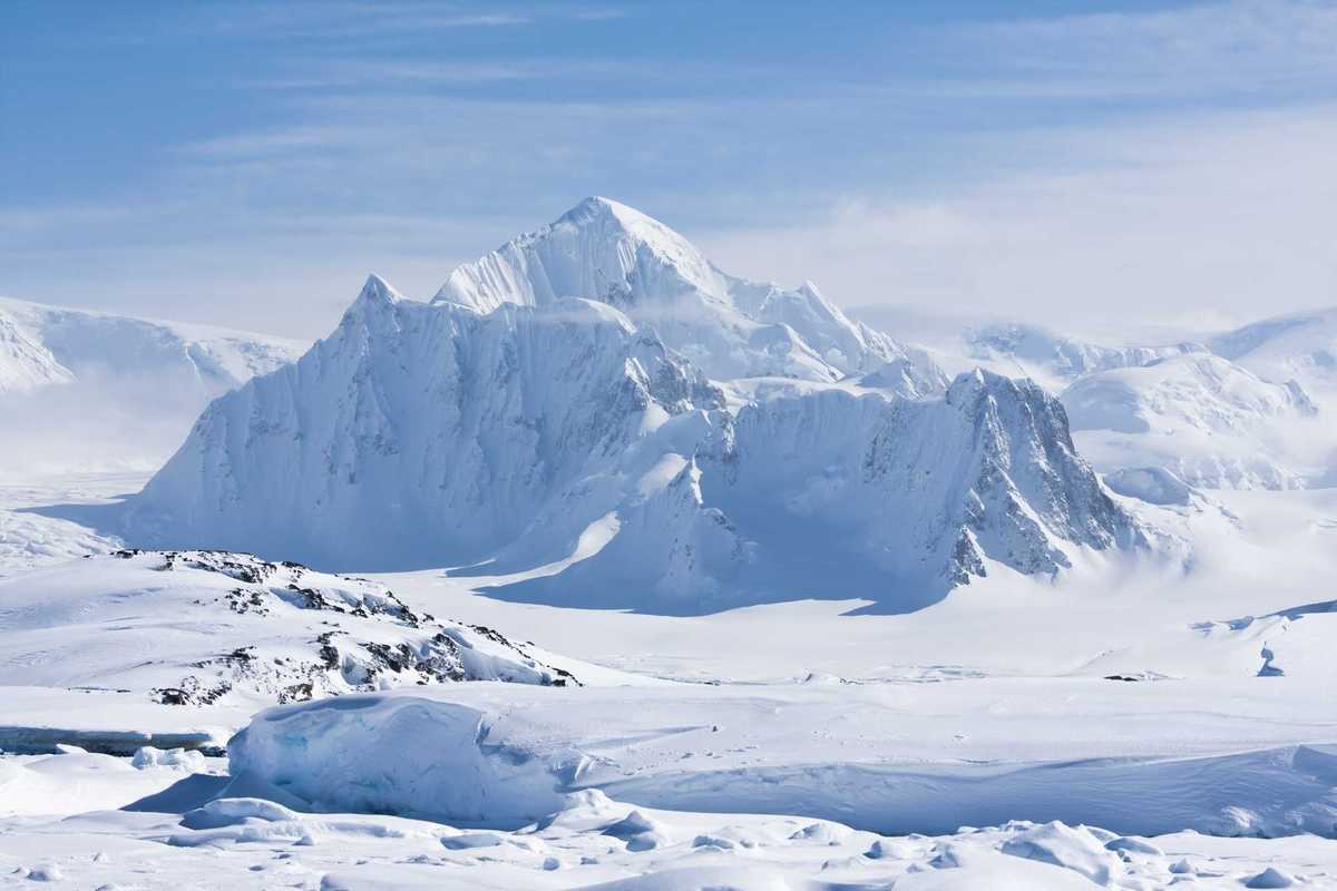 A mountain peak covered with white snow in Antarctica.