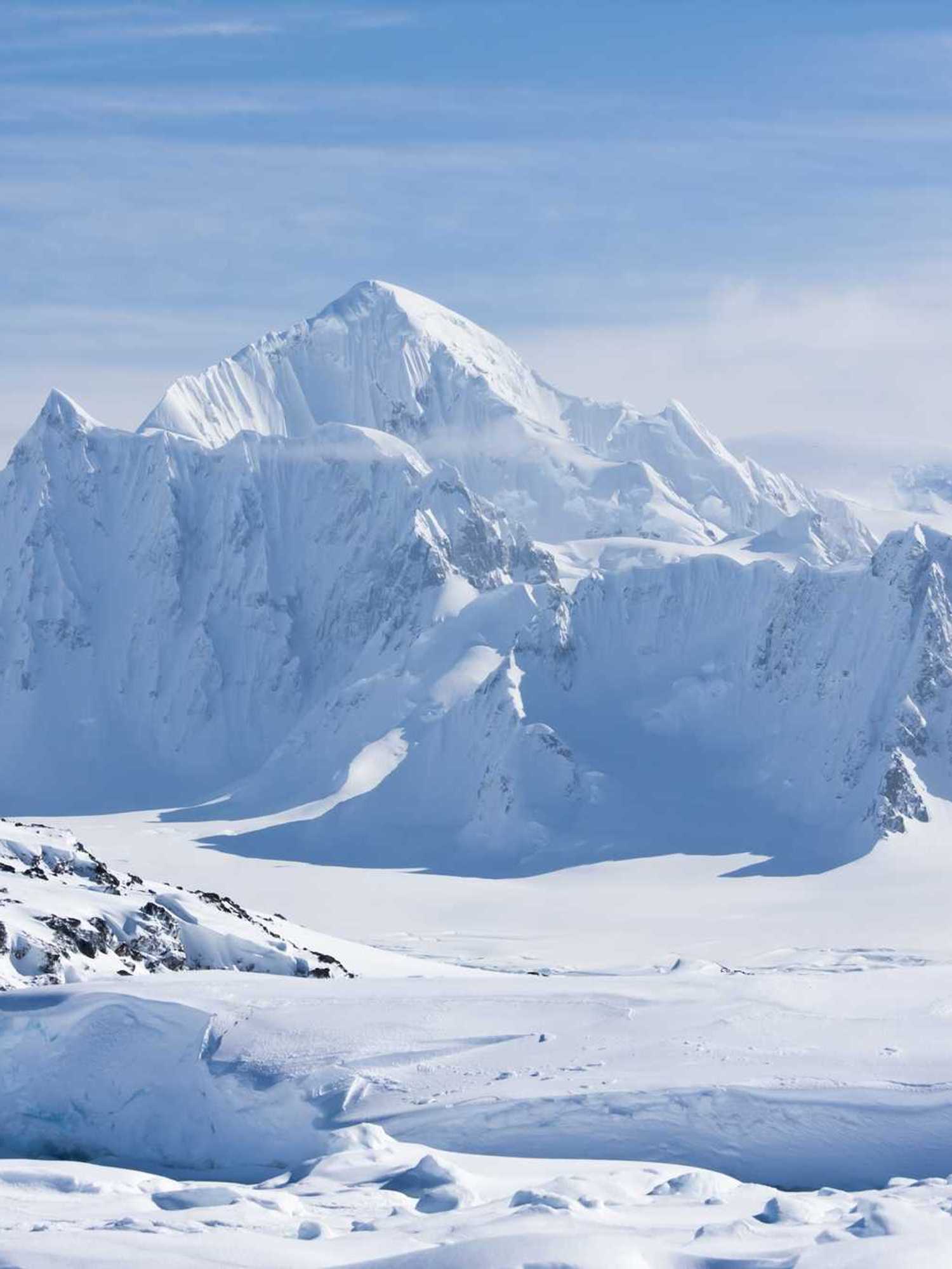 A mountain peak covered with white snow in Antarctica.