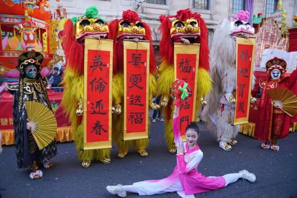 A performer dressed in pink does the splits ahead of Chinese new year celebrations in London