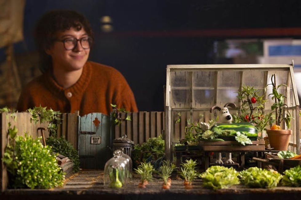 A person looking at a greenhouse set featuring Gromit