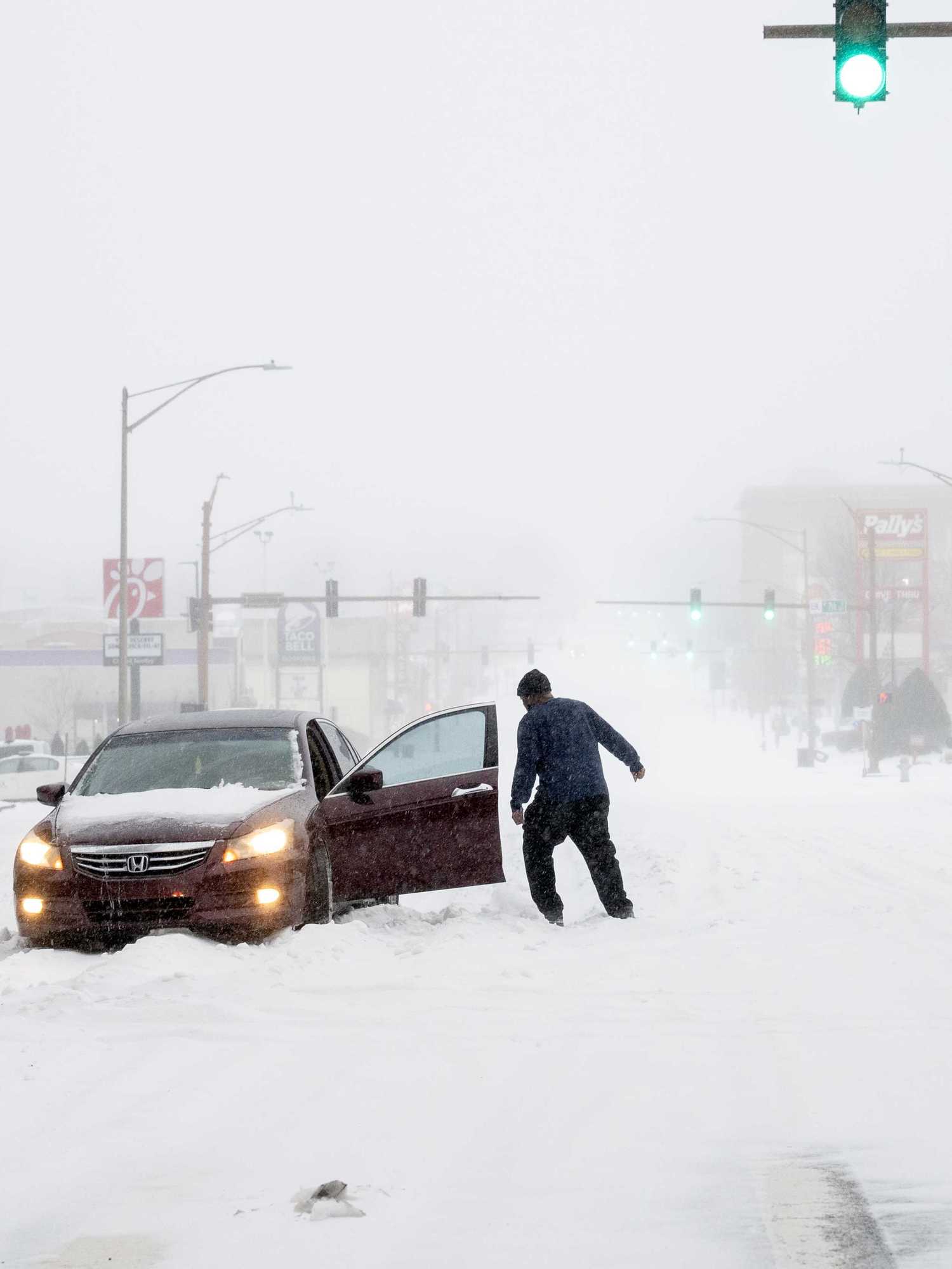 A person's car is stuck in the snow on January 24, 2026 in Little Rock, Arkansas. A massive winter storm is bringing freezing temperatures, ice, and snow to nearly 200 million Americans​