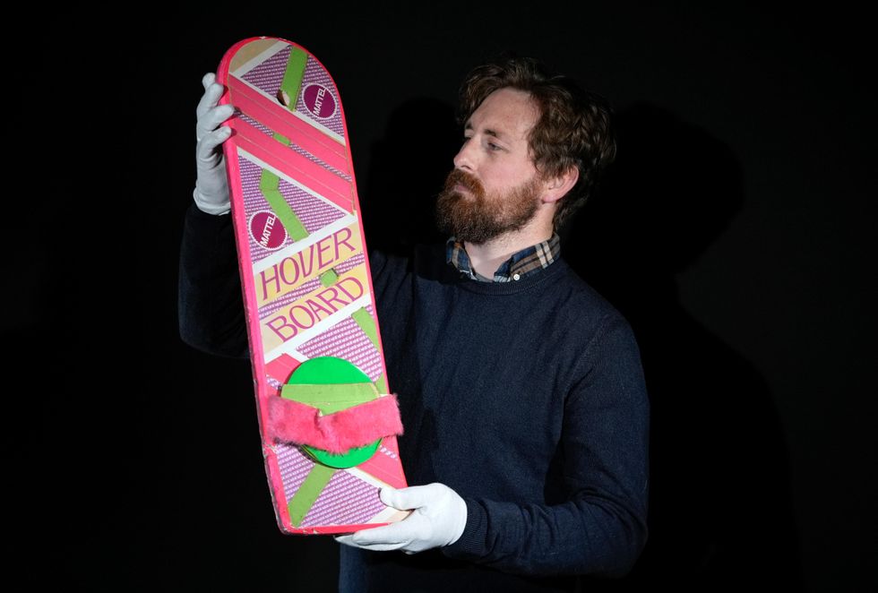 A Propstore employee looks at Marty McFly's (Michael J Fox) Hoverboard from the 1989 and 1990 films Back To The Future Part II and Back To The Future Part III