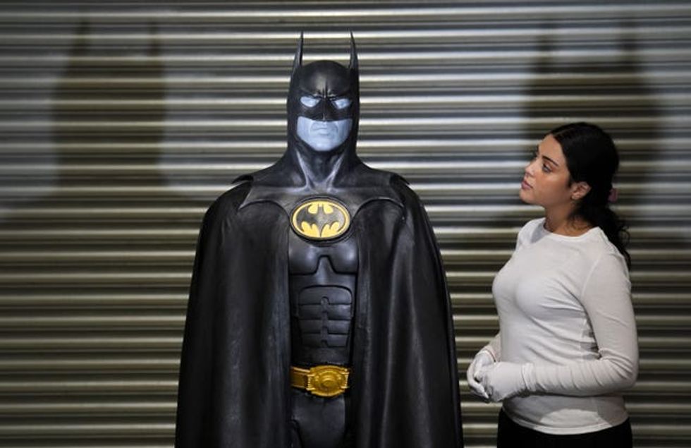 A Propstore employee looks up at Michael Keaton\u2019s batsuit