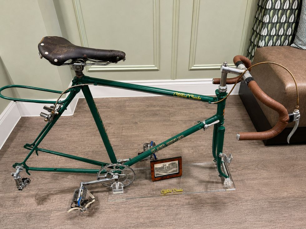 A racing bike, which has a green frame and no wheels