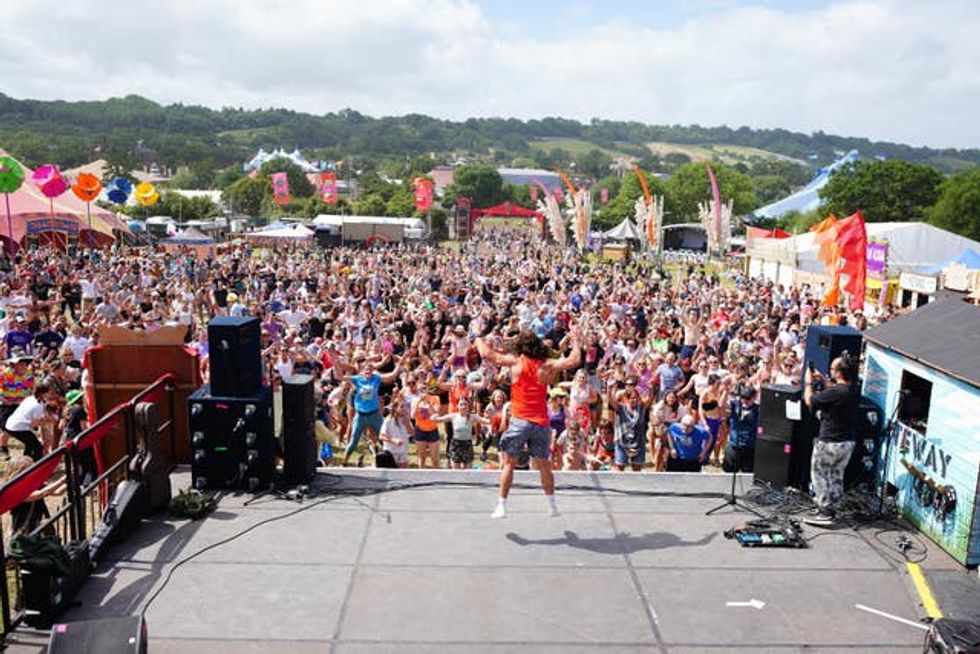 A rear shot of Joe Wicks doing his workout on stage in front of hundreds of people