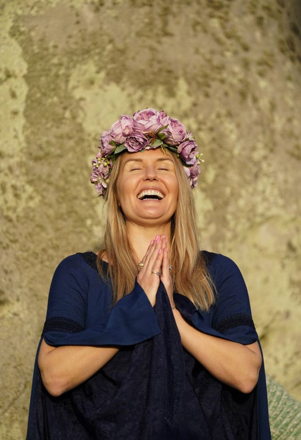 A reveller welcomes the rising of the sun during the summer solstice at Stonehenge (Andrew Matthews/PA)